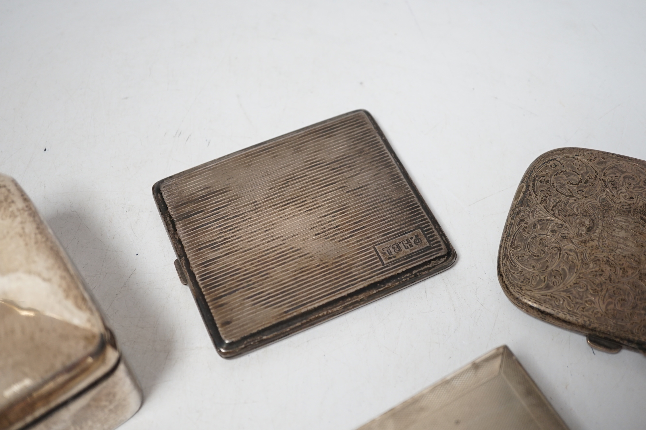 A 1930's engine turned silver cigarette box, 16.6cm, an Edwardian silver cigarette box and two silver cigarette cases.